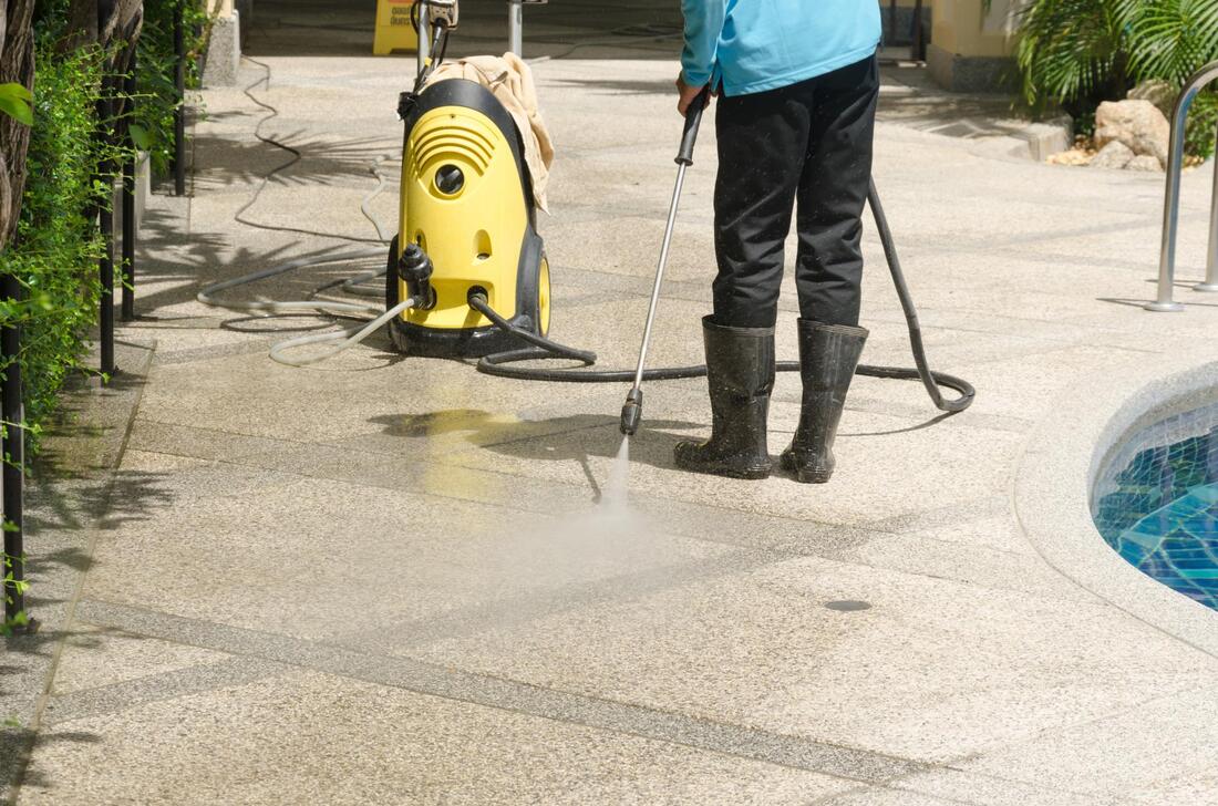 man cleaning the floor beside the pool
